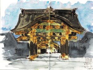 Bogato zdobiona brama Nijō-jō w Kioto: złote i zielone ornamenty pod ciemnym, wygiętym dachem, na tle błękitnego nieba.