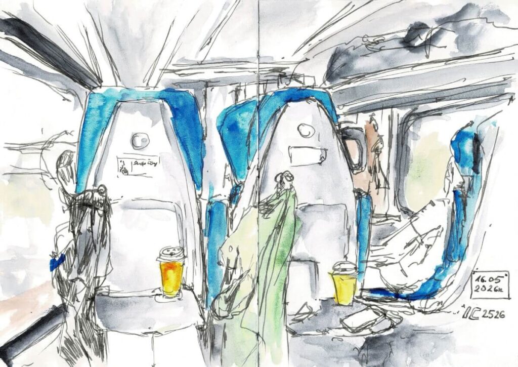 Pociąg do Lublina. Szkic wykonany atramentem wodoodpornym i akwarelą przedstawia niebieskie fotele pociągi interCity, z napojami na stolikach i kurtkami na wieszakach, w tle okna pociągu i sąsiedni rząd foteli.